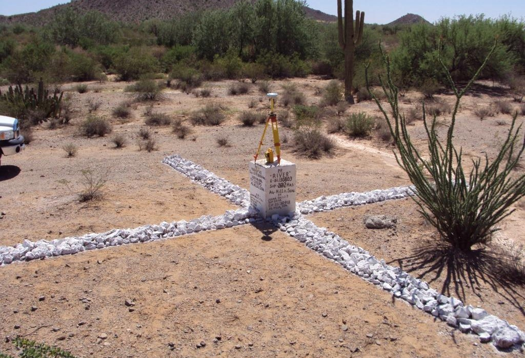 photograph of a good satellite ground target Figure 3a: This target is effective because it was created on even terrain, contrasts the ground colour, and is made from painted rocks that will not blow away or easily be destroyed. The target is clearly visible on the 50cm greyscale satellite image.
Clarification: The ground control target survey elevation must be the ground elevation, not the elevation of the top of the monument.
