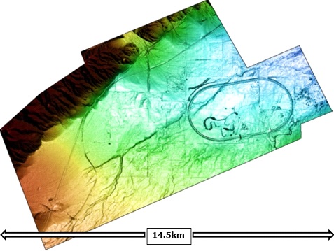 An elevation image showing the portion of the Opentopography.org LiDAR survey used in this accuracy study. The dimensions of the area are 14.5km east–west by 12km north–south. Lower elevations are blue and higher elevations are red. The oval is the Honda California Test Track.